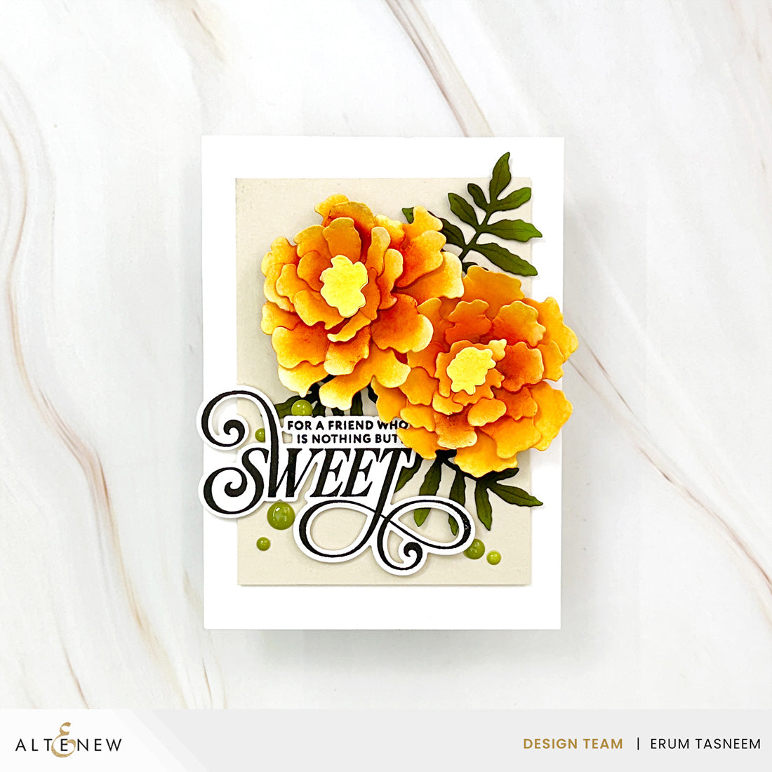A handmade greeting card featuring two large yellow and orange peony flowers with green leaves, layered over a cream background with the word 'SWEET' in black script. The card is photographed on a light marble surface.