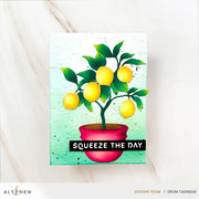 A rectangular greeting card featuring a lemon tree in a pink pot with the text 'SQUEEZE THE DAY' on a black banner, photographed on a light marble surface. The card has a white border and is branded with Altenew at the bottom. Altenew Creative Cuts: Lemon Tree Layering Die Set card ideas