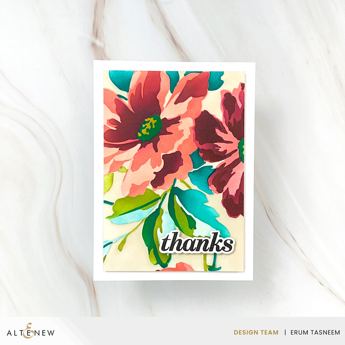 A vertical handmade greeting card with a white border, featuring a colorful floral design in coral, burgundy, teal, and green on a cream background, with the word 'thanks' in black script near the bottom. The card is photographed on a light marble surface, with Altenew branding and designer credits at the bottom of the frame.