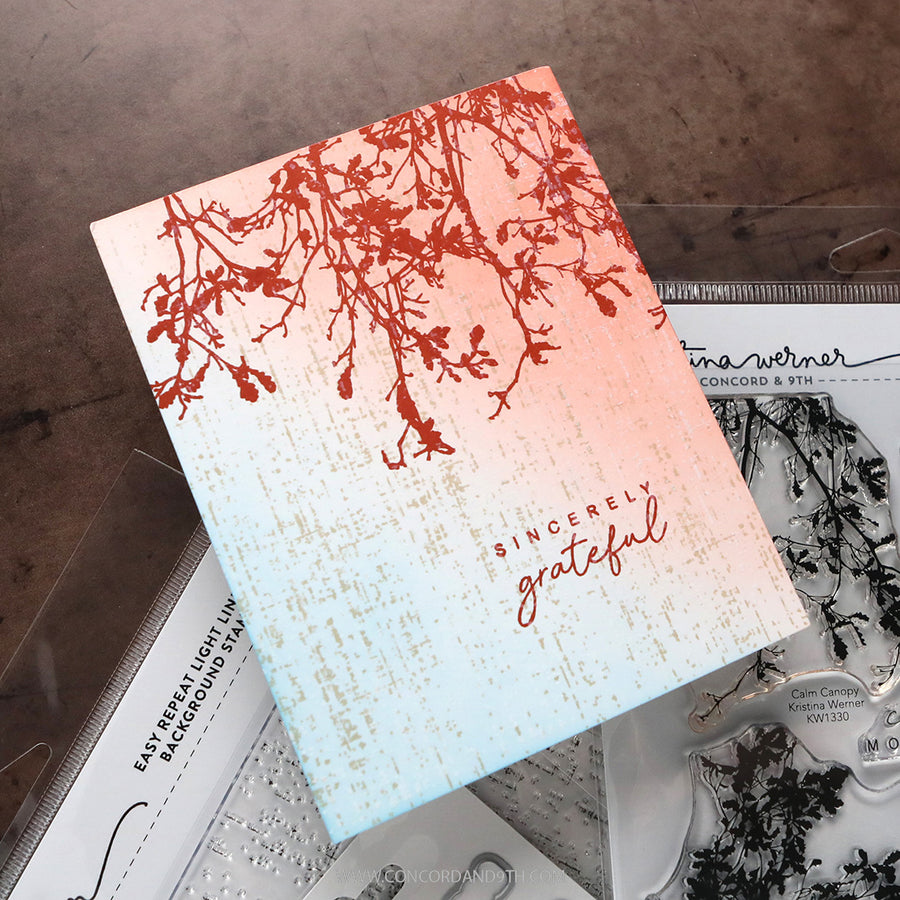 A handmade greeting card featuring a textured light blue and peach gradient with red branch illustrations and the words 'Sincerely grateful' in red script. The card is styled on top of crafting supplies, including a stamp set by Tina Werner.