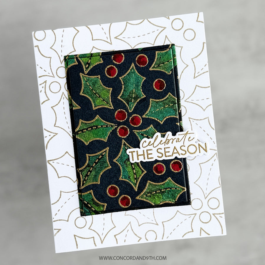 A handmade greeting card featuring a central rectangular panel with a green and black holly pattern and red berries, layered over a white card with gold holly outlines. A die-cut sticker reads 'celebrate THE SEASON' in white and gold.