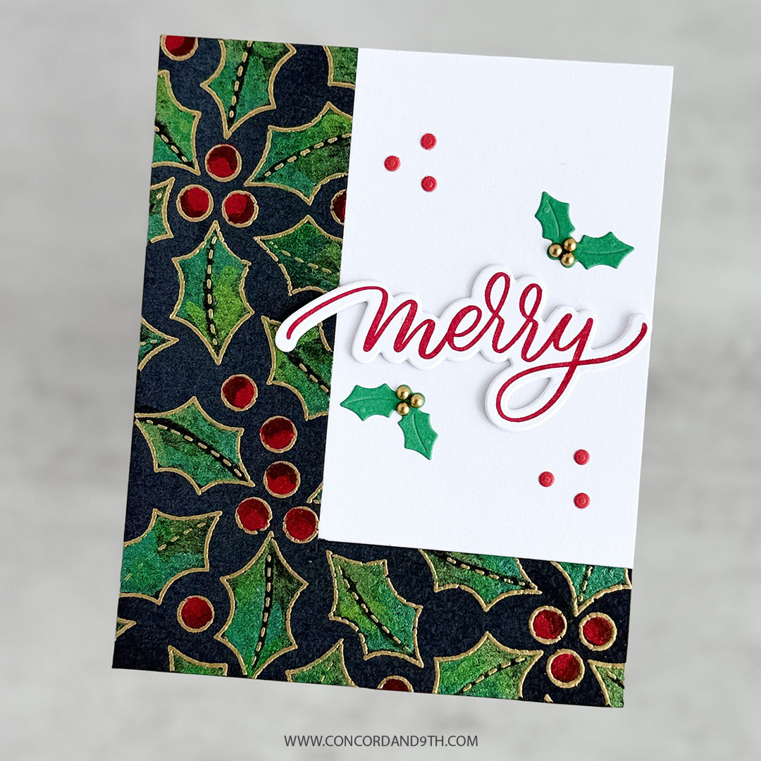 A handmade Christmas greeting card featuring a white center with the word 'merry' in red script, green holly leaves, and red berries, layered over a dark navy and green patterned holly background. The card is shown at an angle on a neutral gray background.