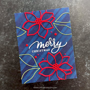 A handmade Christmas greeting card with a dark blue striped background, featuring two red laser-cut poinsettias, lime green leaf outlines, and 'merry CHRISTMAS' in white and silver foil lettering. The card is photographed flat on a dark textured surface.