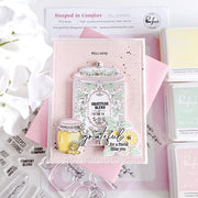 A handmade layered paper craft stamp card featuring a jar of honey with the words 'Gratitude Blend' and 'grateful for a friend like you', styled on a pink background with other crafting supplies.