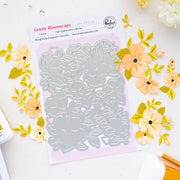 A flat-lay product photo of a 1-piece steel craft die from Gentle Bloomscape by Piinkfresh Studio, displayed on its pink backing card. The die is silver and features a floral leaf pattern.
