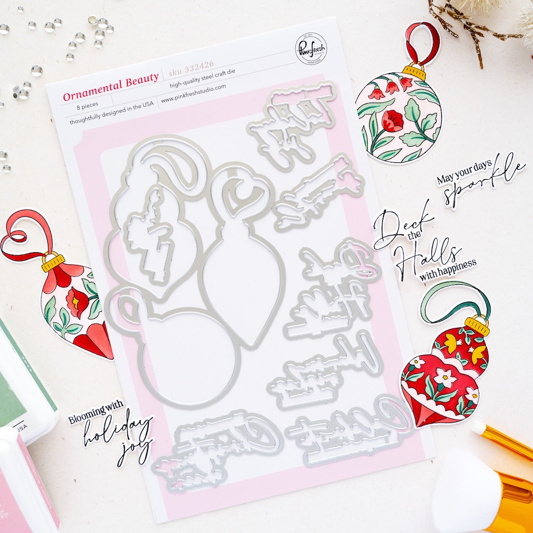 Ornamental Beauty dies featuring holiday ornament designs from Pinkfresh Studio, shown on a white background with coordinating decorated ornaments and crafting tools.