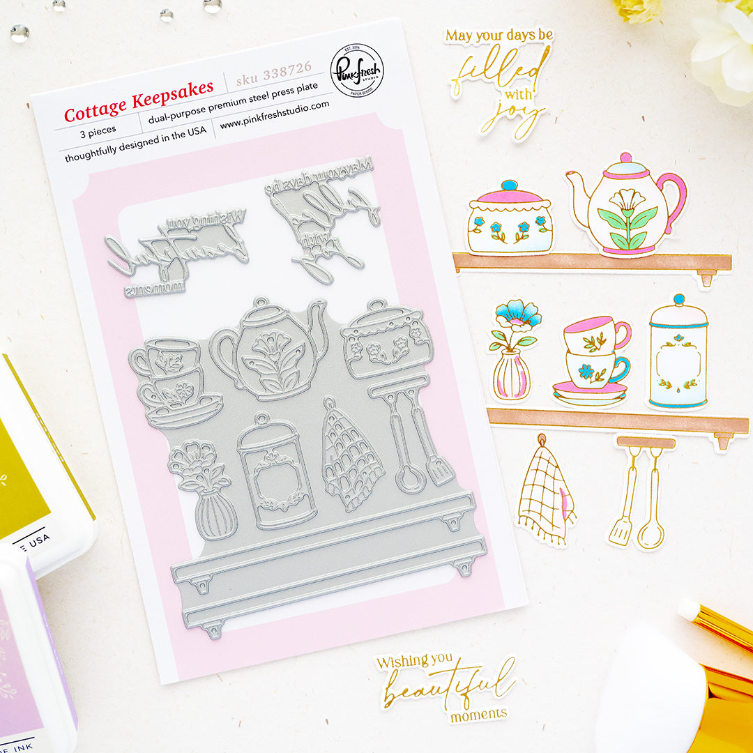 Cottage Keepsakes press plates by Pinkfresh Studio with tea-themed designs, displayed alongside sample stamped and stamped-out results on a white background with decorative gold text and small craft props.