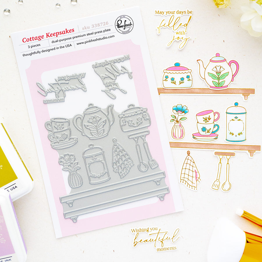 Cottage Keepsakes press plates by Pinkfresh Studio with tea-themed designs, displayed alongside sample stamped and stamped-out results on a white background with decorative gold text and small craft props.