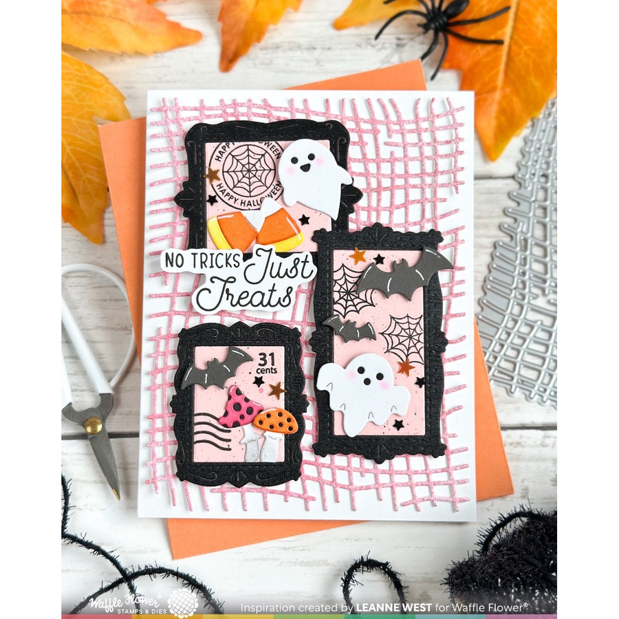 A handmade Halloween greeting card with three black-framed photo panels, white ghosts, bats, spiders, orange pumpkins, and the phrase 'No Tricks Just Treats,' styled on a white wood surface with autumn leaves, scissors, and black spiderwebs.