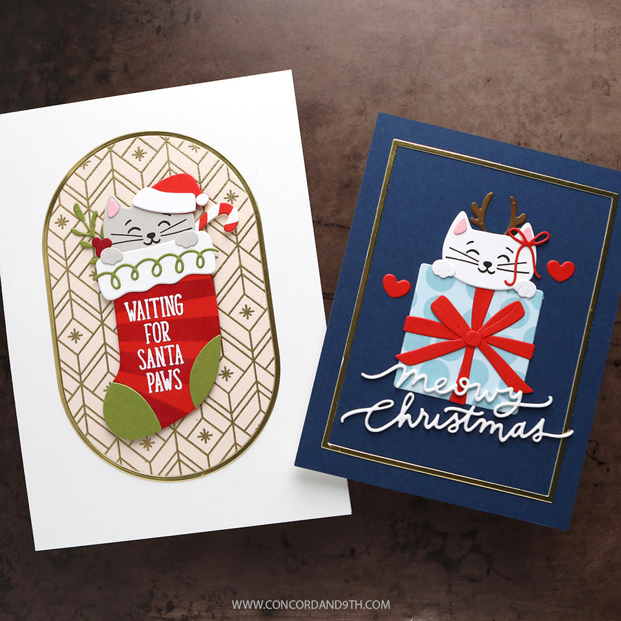 Two handmade Christmas greeting cards displayed on a dark brown textured surface. The left card is white with an oval design featuring a gray cat in a Santa hat peeking out of a red stocking that says 'WAITING FOR SANTA Paws'.