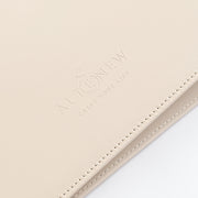 A close-up of a light ivory leather portfolio folder or notebook cover with debossed branding that reads 'ALTENEW' and 'CRAFT YOUR LIFE' on a white background. 