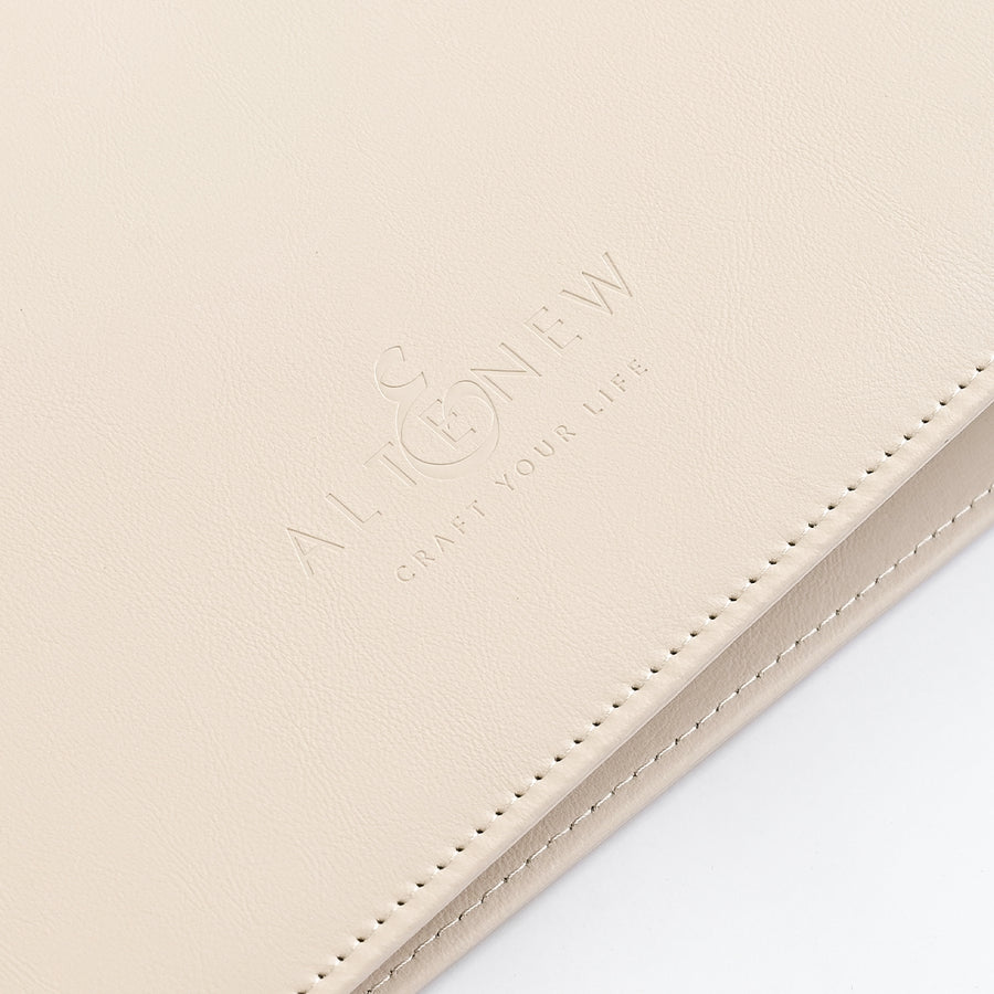 A close-up of a light ivory leather portfolio folder or notebook cover with debossed branding that reads 'ALTENEW' and 'CRAFT YOUR LIFE' on a white background. 