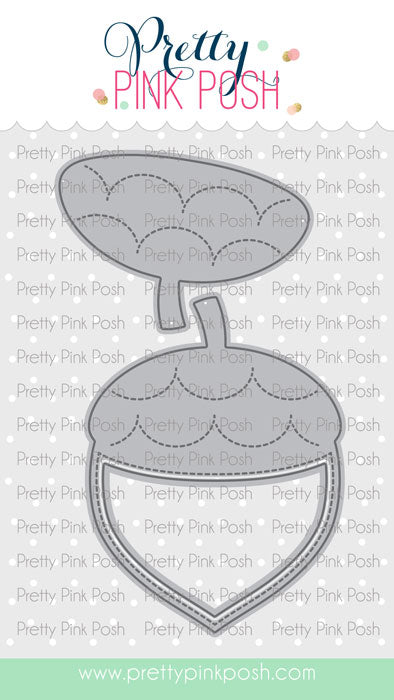 A die-cut craft design from Pretty Pink Posh featuring a gray acorn-shaped outline with dashed stitching details, shown on a white patterned background with the brand name at the top and a website footer. Pretty Pink Posh Acorn Shaker Dies