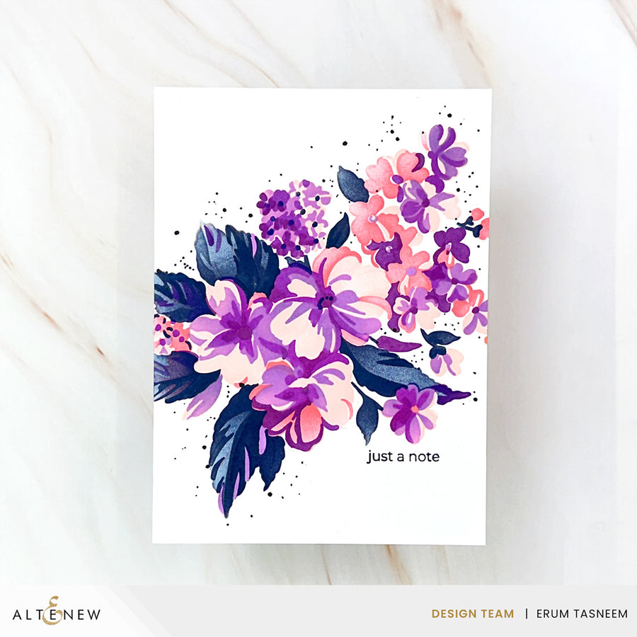 A vertical art print or card featuring a watercolor floral bouquet in purple, pink, and navy on a white background, with the text 'just a note' near the lower right. The print is photographed on a light marble surface, with ALTENEW branding and designer credits along the bottom. Altenew Build-A-Garden: Softly Sketched Blooms