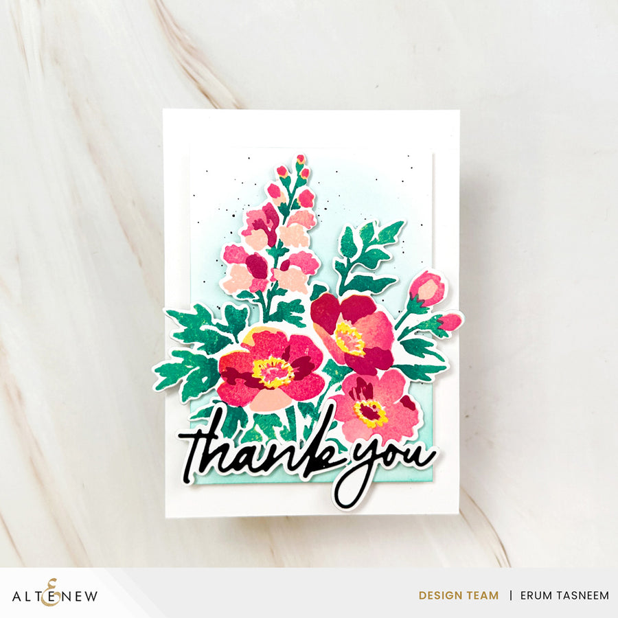 A handmade layered card featuring a watercolor-style floral arrangement in pink, red, and green with the words 'thank you' in black script, photographed on a light marble surface. Altenew Craft Your Life Project Kit: Painterly Perfection card ideas