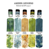 Five small jars of ink or pigment labeled 'Lindy's Gang' are shown above six matching rectangular color swatches, with text reading 'AMBER LEDGERS' and shade names including Lichen Ledgers, Moody Mist, Cedar & Sass, Moss Boss, and Deep River Denim on a white background. Lindy's Gang Amber Ledgers by Katie Pertiet Magical Shimmer Shaker Set (5 Pack)