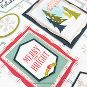 A close-up of layered handmade holiday cards with layered paper borders, green tree cutouts, and the words “MERRY AND BRIGHT,” shown on a white background with other card elements partially visible.