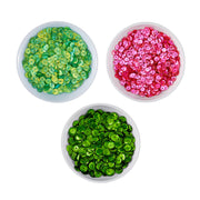 Three small white bowls filled with round sequins, arranged on a white background: one green-and-yellow mix, one bright pink, and one vivid green. Spellbinders Festive Felt Christmas Sequin Bundle