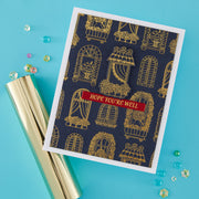 A handmade greeting card with a navy blue background, gold window patterns, and a red banner reading 'HOPE YOU'RE WELL', styled on a bright blue surface with a gold foil tube and scattered decorative beads.