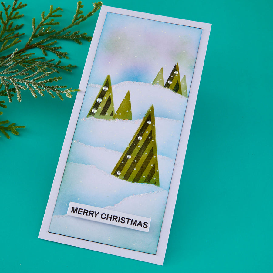 Christmas card with snowy trees and 'Merry Christmas' text on a teal background