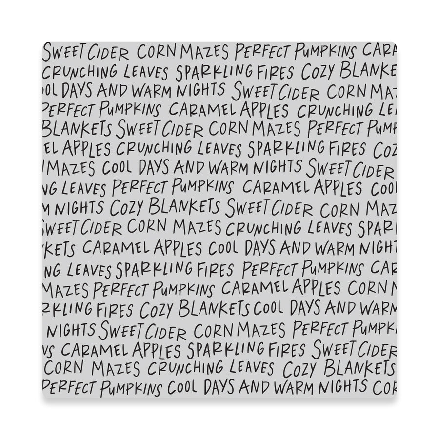 A cling stamp featuring a hand-written style gray text pattern on a white background, with the text reading 'SWEET CIDER CORN MAZES PERFECT PUMPKINS CARAMEL APPLES CRUNCHING LEAVES SPARKLING FIRES COZY BLANKETS' and repeating around the border.