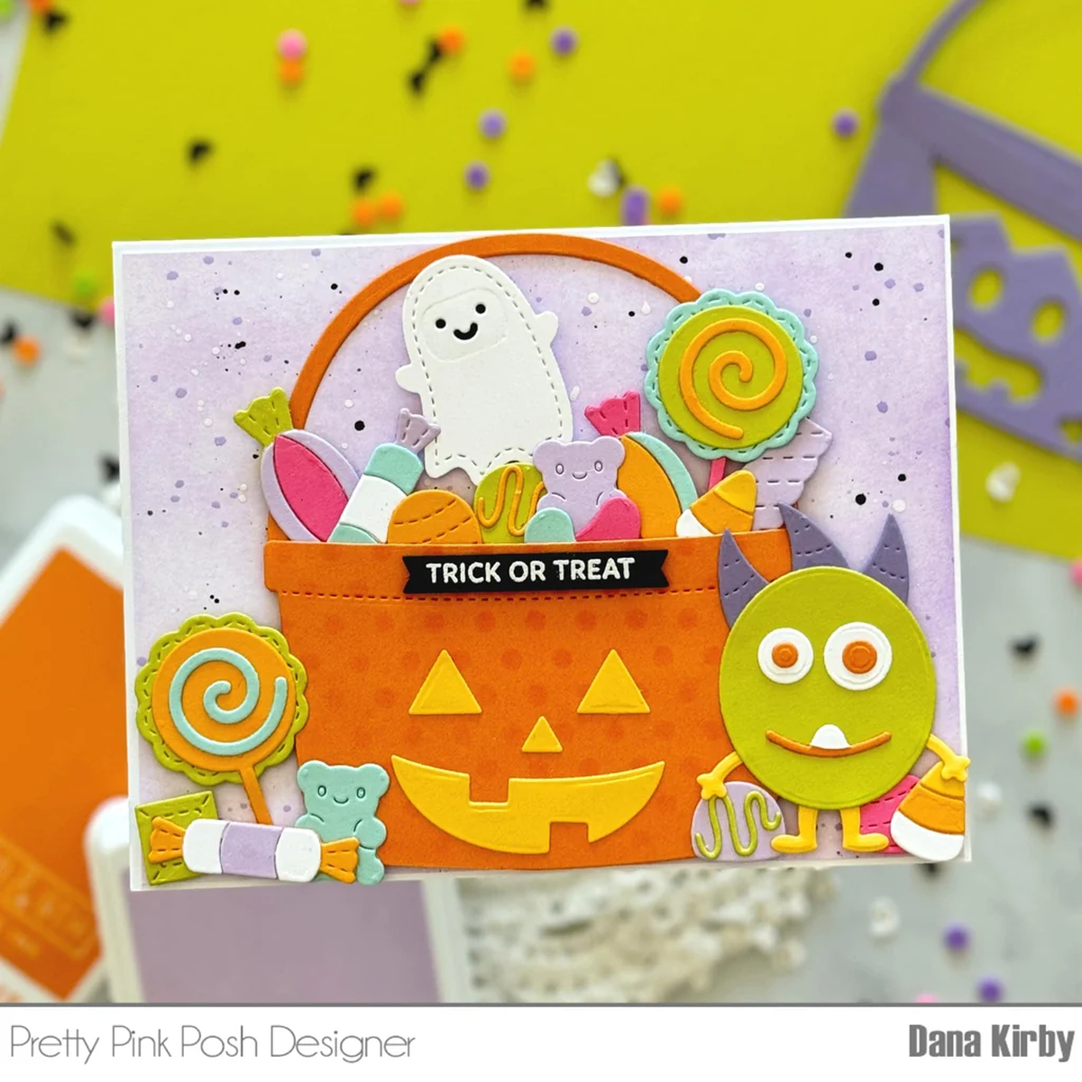 Halloween-themed card with candy basket, ghost, and monster design on a colorful background.