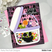Halloween-themed card with a purple bag and candy decorations on a pink and black background.