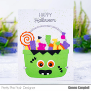 Halloween-themed card with a green monster face basket and candy decorations on a white background.
