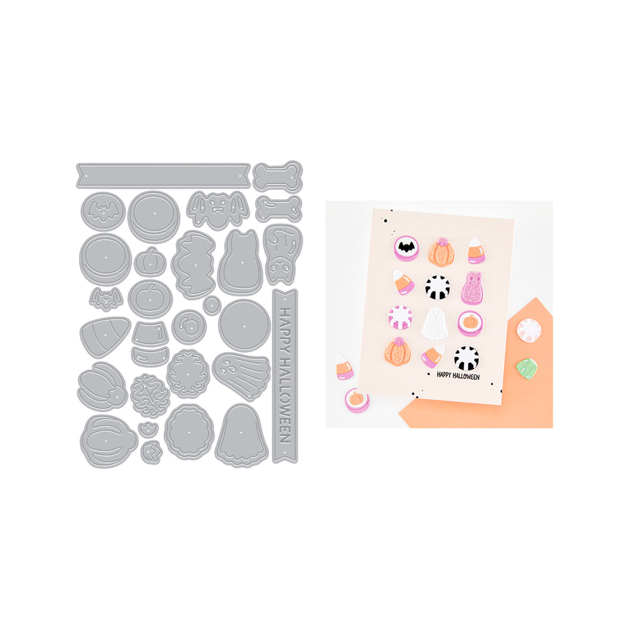 A Halloween-themed crafting kit featuring a gray metal die-cutting sheet with various cute shapes like pumpkins, ghosts, bats, and candy, alongside a sample card decorated with colorful stickers and a peach envelope on a white background.