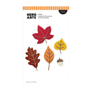 Hero Arts Lovely Little Leaves die set package, featuring five autumn leaf shapes (red maple, brown oak, orange leaf, yellow leaf, and acorn) on a white card with orange and black branding.