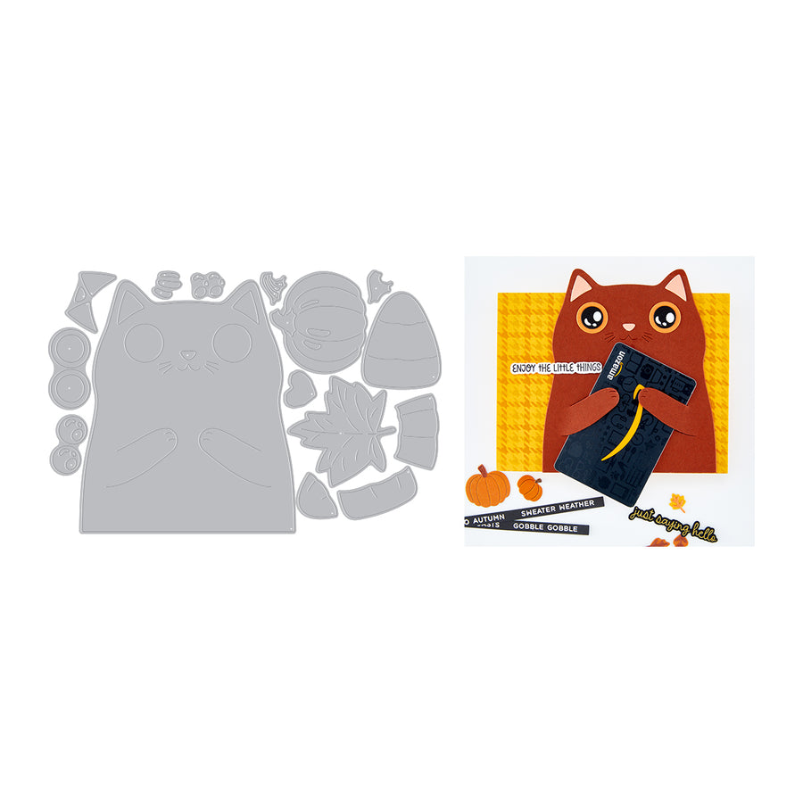 A flat lay showing a gray layered paper craft die set on the left and a completed autumn-themed card design on the right. The card features a brown cat holding a black book against a yellow patterned background, with small orange pumpkins and black text strips reading 'HAPPY PUMPKIN SCENERE' and 'HAPPY SCENERE PUMPKIN'.