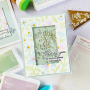 Handmade card with floral design and 'thank you' message on a crafting table.