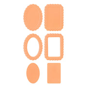 Six peach-colored paper cutters or dies in various shapes including two oval frames, two rectangular scalloped frames, and two solid shapes, arranged on a plain white background. Spellbinders Scalloped Frames 3D Emboss & Cut Folder