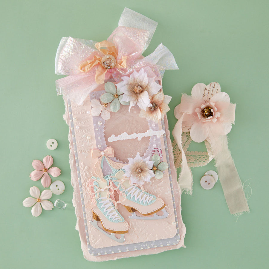 A decorative handmade card or art piece featuring a pair of pastel ice skates, embellished with 3D flowers, lace, and a large bow, displayed on a mint green background alongside matching floral embellishments. Also features Spellbinders Sparkling Trees 3D Embossing Folder by Frank Garcia