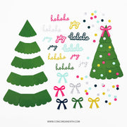 A flat lay of Christmas-themed paper craft pieces on a white background, including two green tree shapes, pink and green ho-ho-ho and joy text elements, colorful confetti dots, and ribbon bows in pink, green, navy, and silver glitter.