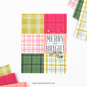 A handmade greeting card featuring a 2x3 grid of colorful plaid and checkered patterns in yellow, pink, green, and white, with a central 'MERRY AND BRIGHT' text and holly graphic. The card is displayed on a white background with decorative patterned paper scraps in the corners.