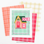 A handmade Christmas greeting card featuring a cute pink house with a green roof and the word 'NOEL' in pink letters, layered over three plaid patterned cardstock sheets in coral, yellow, and red. The brand name 'Concord and 9th' is visible at the bottom.