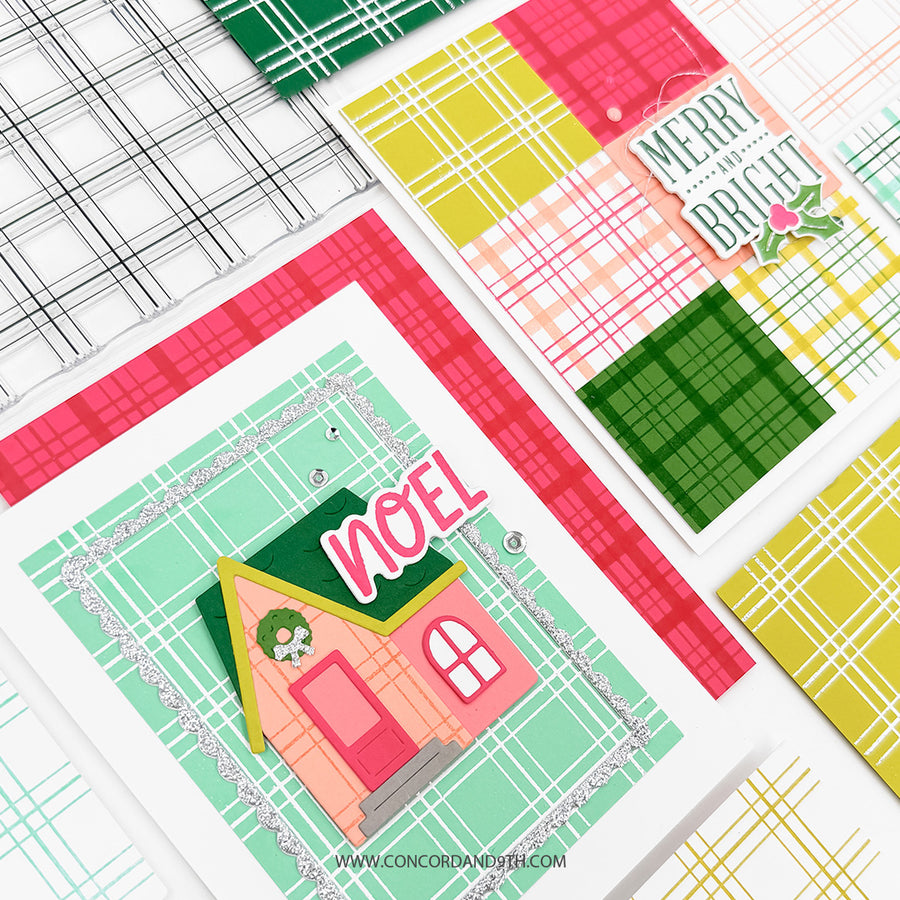 A flat-lay of handmade holiday greeting cards featuring a colorful layered house design with the word 'NOEL' and a plaid patterned background, alongside other cards with plaid and geometric designs.
