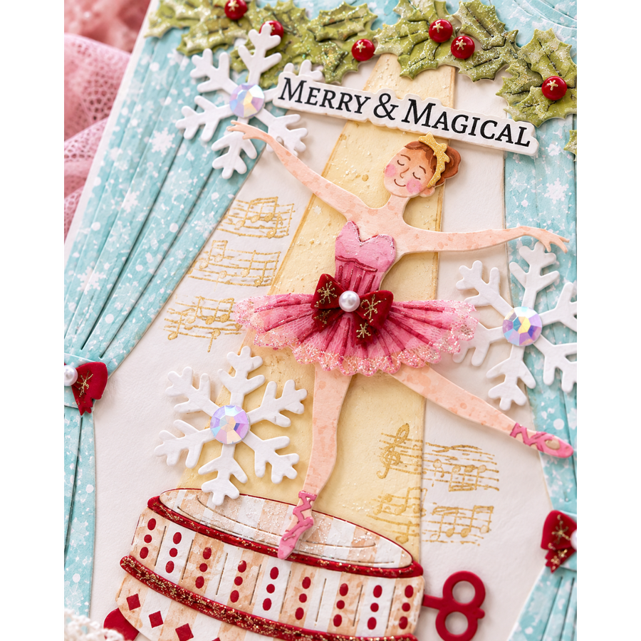 A close-up of a decorative holiday card featuring a ballerina figure in a pink tutu, snowflakes, musical notes, green holly with red berries, and the text 'MERRY & MAGICAL'.