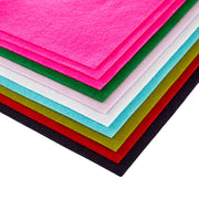 A stack of colorful felt sheets in bright pink, green, white, light blue, olive green, red, and black, arranged diagonally on a white background. Spellbinders Merino Wool Felt Sheets - Festive Collection