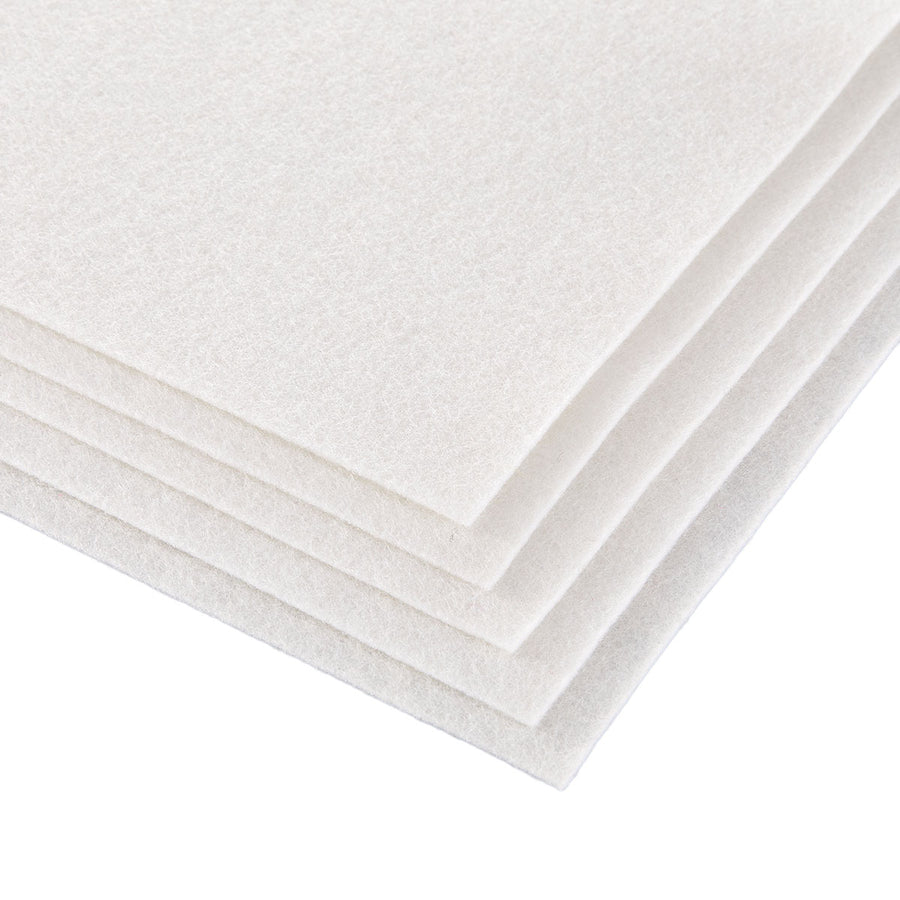 A stack of off-white felt or foam sheets with a soft, textured surface, shown at an angle on a plain white background. Spellbinders Merino Wool Felt Sheets - Snow