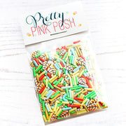 A clear plastic bag filled with colorful sprinkles and autumn leavess, sealed with a white paper header card that reads 'Pretty Pink Posh' in decorative lettering, photographed on a white wood surface. Pretty Pink Posh Fall Fling Clay Confetti