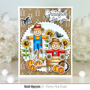 A handmade autumn-themed greeting card featuring two scarecrows, sunflowers, pumpkins, birds, and the text 'Grateful for you!' on a white and kraft paper background, displayed with blurred white flowers.
