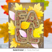 A handmade autumn-themed card featuring the word 'FALL' in large outlined letters filled with pink, orange, and yellow craft beads, surrounded by layered yellow and pink fall leaves on a brown background. The card is presented with a blurred background of colorful leaves, and the text 'Rachel Kruiver for Pretty Pink Posh' is visible at the bottom.