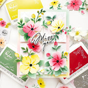 A floral greeting card with layered paper flowers and the words “Miss you” in script, surrounded by Ranger brand ink pads and craft tools on a white background.