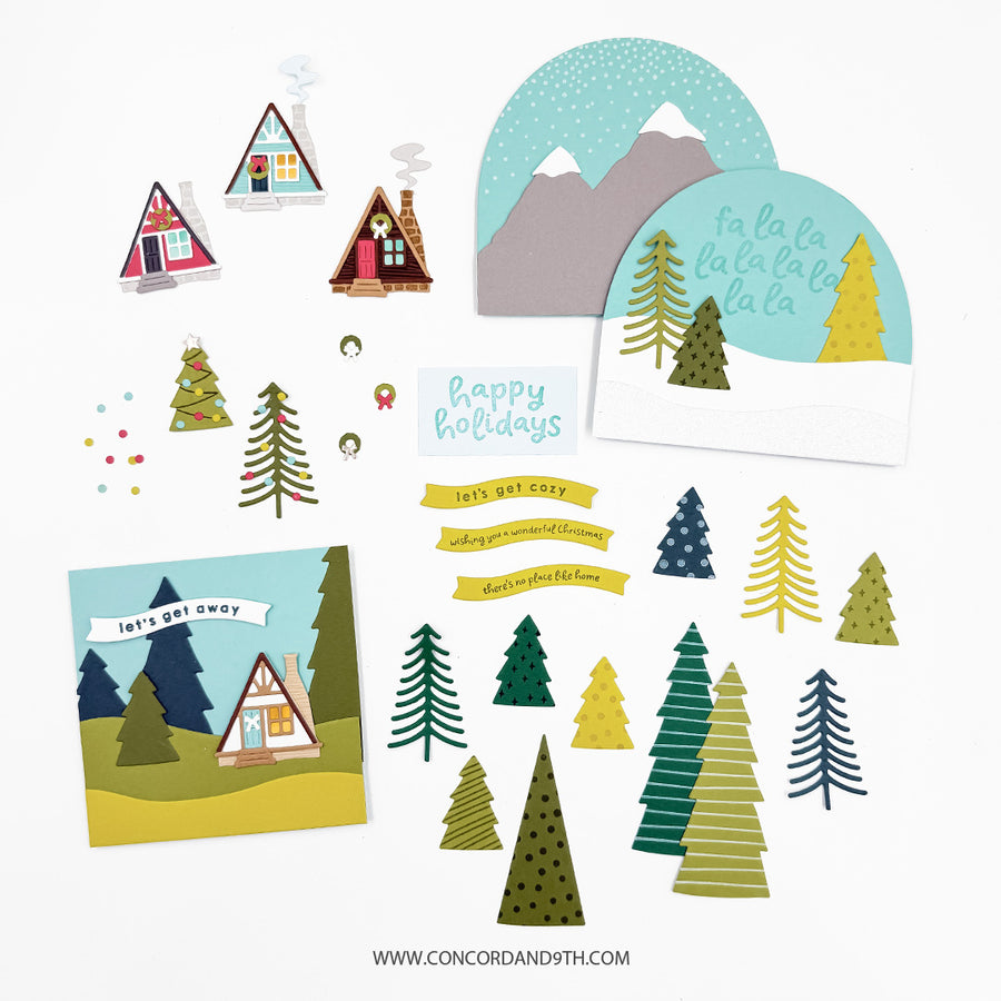 A flat lay of winter-themed elements on a white background, including mountain and forest illustrations, small houses, evergreen trees, banners, and holiday text elements.