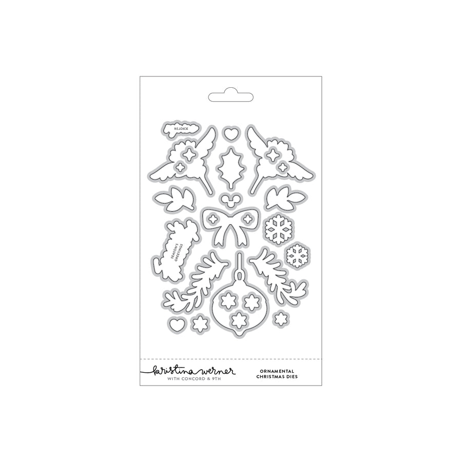 A packaged set of Christmas-themed metal cutting dies on a white backing card, featuring angel wings, ornaments, bows, leaves, snowflakes, and other festive shapes. The card shows the brand name 'Kristina Werner' and the text 'Ornamental Christmas Dies'.
