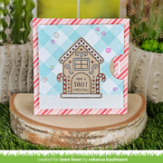 A handmade Christmas greeting card featuring a gingerbread house with the text 'HAVE A SWEET CHRISTMAS' on a light blue and white gingham background with pink striped borders. The card is displayed on a rustic wood slice with cacti in the background.