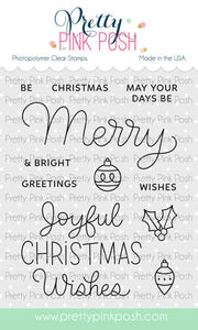 A sheet of Pretty Pink Posh photopolymer clear stamps featuring Christmas-themed phrases and ornaments, shown on a white background with the brand name at the top and a website URL at the bottom. Pretty Pink Posh Merry Greetings Stamp Set