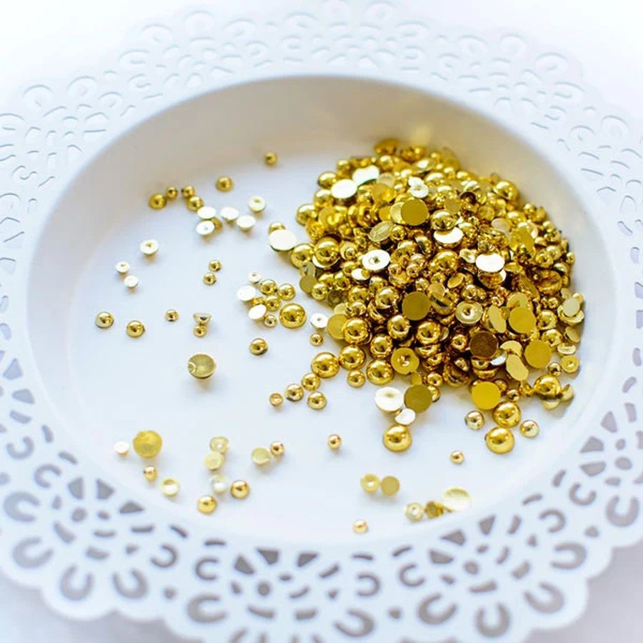 Gold metallic craft embellishments, including flat round sequins and small dome beads, scattered on a white scalloped plate. Pretty Pink Posh Metallic Gold Pearls